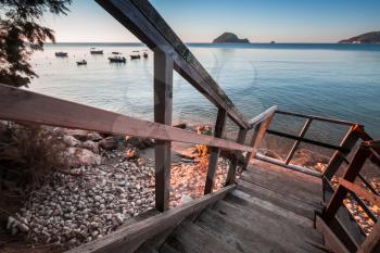 Perspective view of wooden stairs going down to beach. Coast of Zakynthos island, Greece