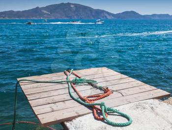 Colorful nautical ropes lay on wooden pier. Zakynthos island, Greece