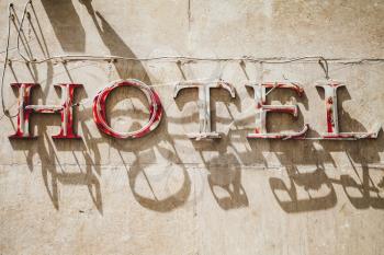 Hotel. Grungy advertising neon sign on an old building facade