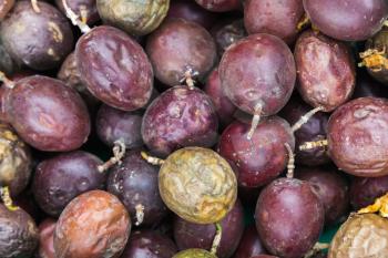 Purple passion fruits lay on the counter of street food market on Madeira island, Portugal. Close-up photo with selective focus