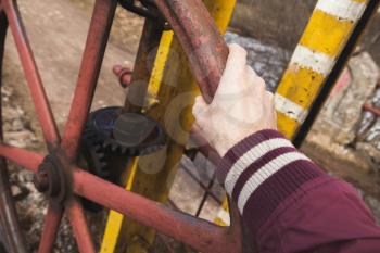 Male hand on industrial grungy handwheel, close-up photo