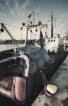 Industrial fishing boats are moored in port of Nesebar, Bulgaria. Vintage tonal correction filter, retro style effect
