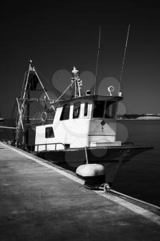 Fishing boat stands moored in port of Nesebar, Bulgaria. Black and white high contrast photo