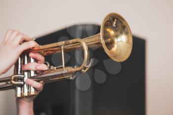 Live music background, trumpet in trumpeter hands. It is a brass instrument commonly used in classical and jazz ensembles, close-up photo with selective focus