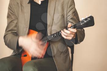 Russian folk music background, Man fast playing balalaika, close up photo with soft selective focus and motion blur effect