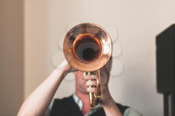 Live music background, Trumpeter with a trumpet in hands, close-up front view photo with selective focus