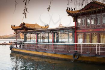 Chinese wooden floating restaurant moored near West Lake coast. Famous park in Hangzhou city, China