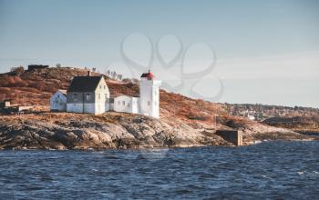 Terningen Lighthouse. White navigation tower with red top. Coastal lighthouse located in Hitra Municipality, Trondelag county, Norway