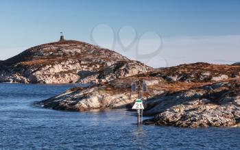 Stone Cairn and new lighthouse, Norway. Traditional Scandinavian navigation sea marks near rocky islands