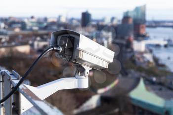 Observation closed-circuit television camera mounted on a rooftop of a port building in Hamburg harbor, Germany