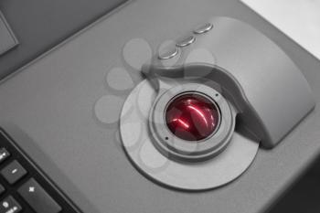 Industrial control panel made of gray steel with red trackball, close up photo with soft selective focus