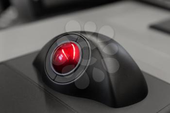 Industrial control panel with red trackball, close up photo with soft selective focus