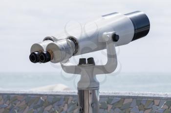 Binocular telescope on a rotating base mounted on an outdoor touristic viewpoint