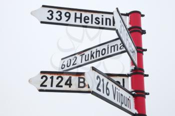 Red signpost, directional signs with distances to destination cities. Savonlinna, Finland