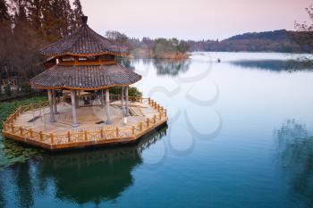 Chinese traditional wooden gazebo on the coast of West Lake, public park in Hangzhou city, China