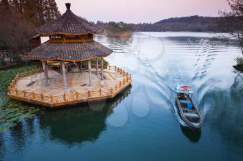Chinese traditional wooden gazebo on the coast of West Lake, popular public park of Hangzhou city, China