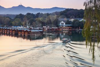 Chinese fishing boat goes on the West Lake. Famous public park in Hangzhou city, China