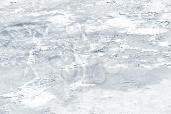 Fresh thin ice covered with show on frozen river in winter season, natural background photo texture