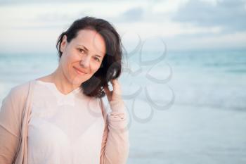 Young adult Caucasian woman, outdoor portrait on the ocean coast in early morning