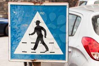 Pedestrian crossing. Old square blue and white road sign with schematic walking man in hat