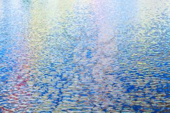 Colorful reflections pattern over ripple water surface. Abstract background photo
