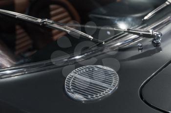 Air intake grille and windscreen wiper. Luxury vintage car fragment, close up photo with selective soft focus
