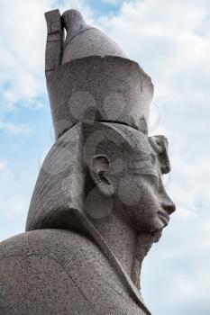 Granite sphinx profile. Ancient monument on blue cloudy sky background. Landmark of Neva river coast in St.Petersburg, Russia
