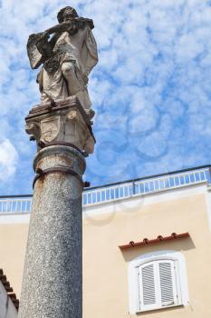 Ancient stature on stone column, old town of Lacco Ameno. Ischia, Italian island in the Tyrrhenian Sea