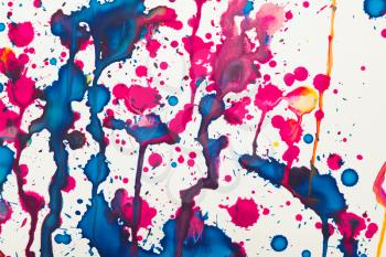 Colorful paint splashes artistic pattern over white paper, background texture