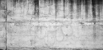 Old grungy concrete wall with dark wet stains, frontal background photo texture
