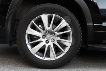 Modern automotive wheel on light alloy disc, close up photo