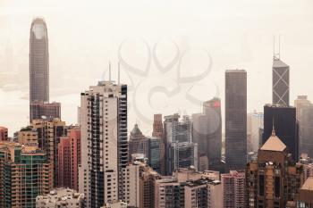 Modern skyline of Hong Kong city, aerial view taken from Victoria Peak viewpoint in foggy summer day