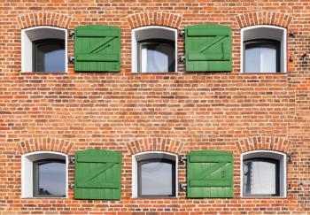 Red brick wall with small windows, background photo texture. Copenhagen, Denmark