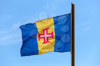 Flag of Madeira. Blue-gold-blue vertical triband with a red-bordered white Cross of Christ in the center
