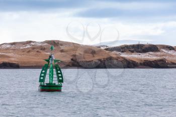 Green framed buoy with cone topmark. Navigation equipment of Reykjavik, Iceland