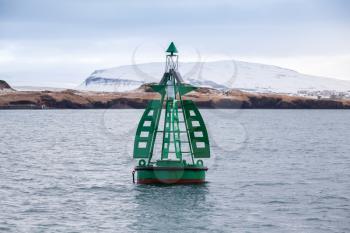 Green framed buoy with cone topmark. Navigation equipment of Reykjavik bay, Iceland