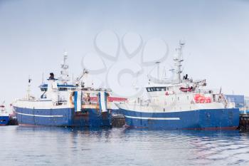 Industrial fishing ships. Blue white trawlers stands moored in port of Reykjavik, Iceland