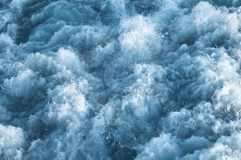 Dark blue stormy ocean water with splashes and foam, natural background photo texture