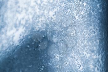 Frost pattern on window glass close up abstract background photo with selective focus