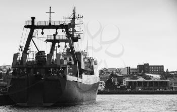 Industrial trawler ship stands moored in port of Reykjavik, Iceland. Stern view, black and white