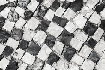 Typical portuguese cobblestone handmade pavement pattern of black and white squares. Lisbon, Portugal