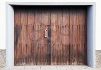 Closed wooden gate in white concrete wall. Background photo texture