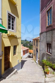 Vertical photo of an empty street of old Sintra, Portugal. Colorful living houses facades