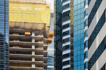 Modern building under construction, concrete floors. Facade fragment with scaffolding structures