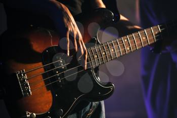 Electric bass guitar player hands, soft selective focus, live music theme