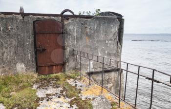 Rusted steel door, entrance to abandoned bunker from WWII period on Totleben fort island in Gulf of Finland near Saint-Petersburg in Russia