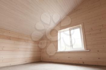 Empty new attic room interior, wooden walls and window