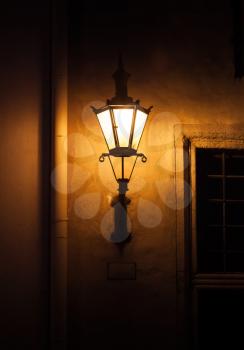 Old street lamp light on the wall at night. Old town of Tallinn, Estonia