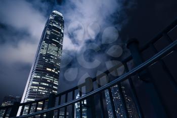 Hong Kong city at night, illuminated skyscrapers under dramatic cloudy sky