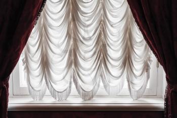 Waving tulle and dark red curtain cover white window. Background photo texture